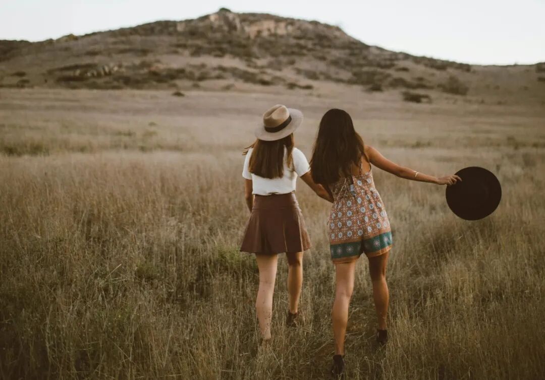 two women walking around near mountain at daytime