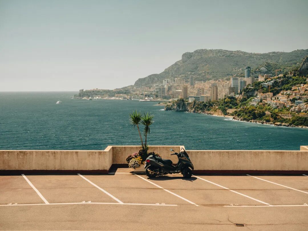 a motorcycle parked on the side of a road next to the ocean