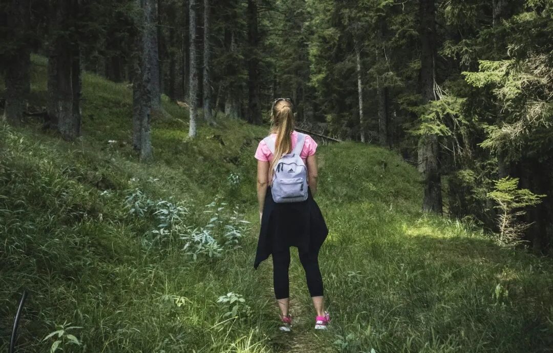 woman carrying backpack on forest