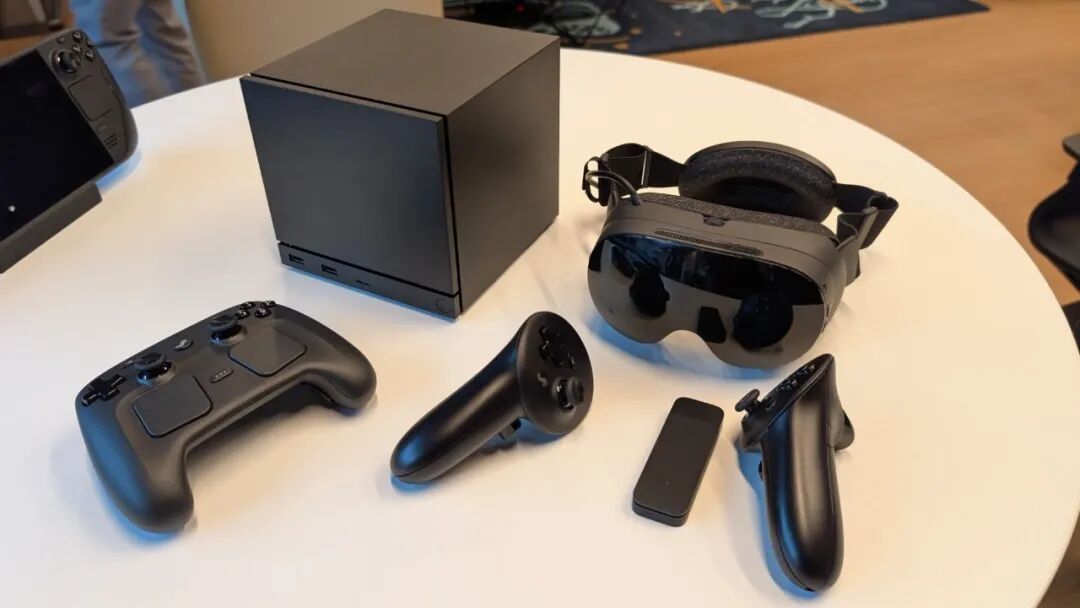 The new (for 2026) Steam Machine, Steam Controller, and Steam Frame VR headset laid out on a table.