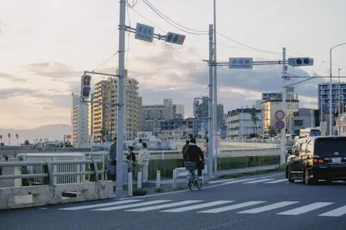 免费 日本沿海城市的一个宁静的夜晚，有交通灯、建筑物和骑自行车的人。 素材图片
