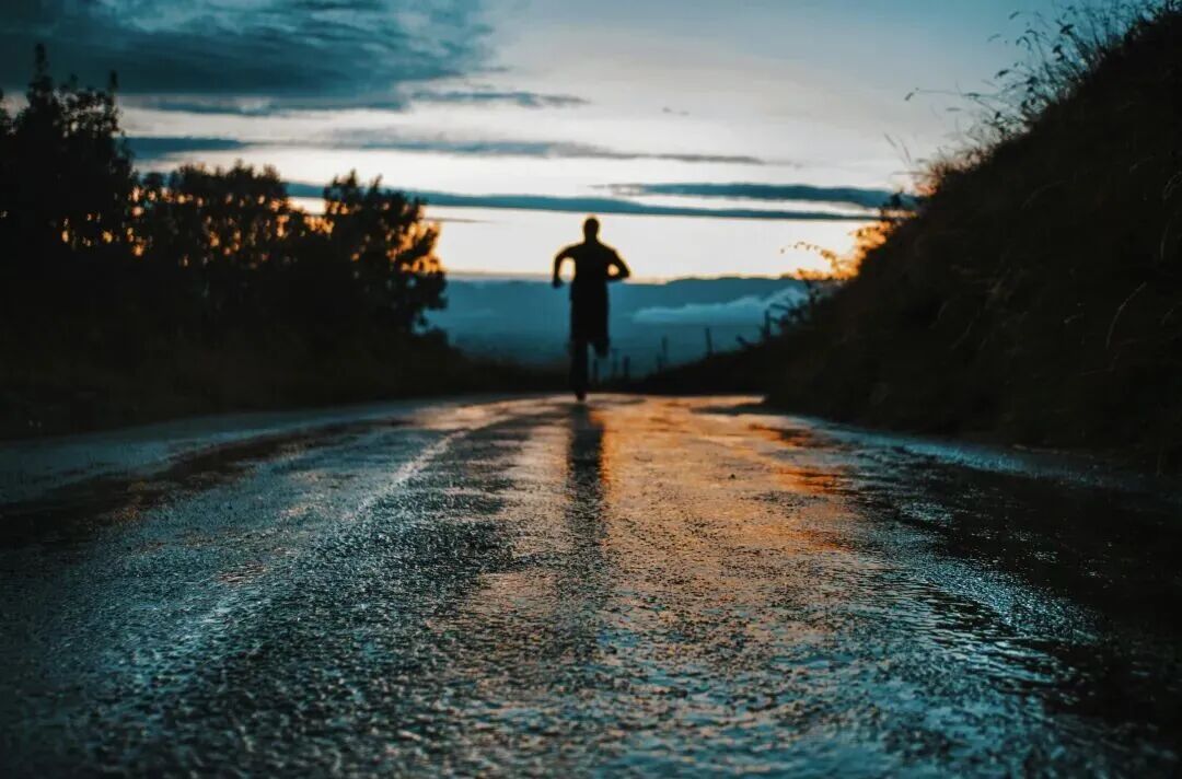 silhouette photo of a person running on road