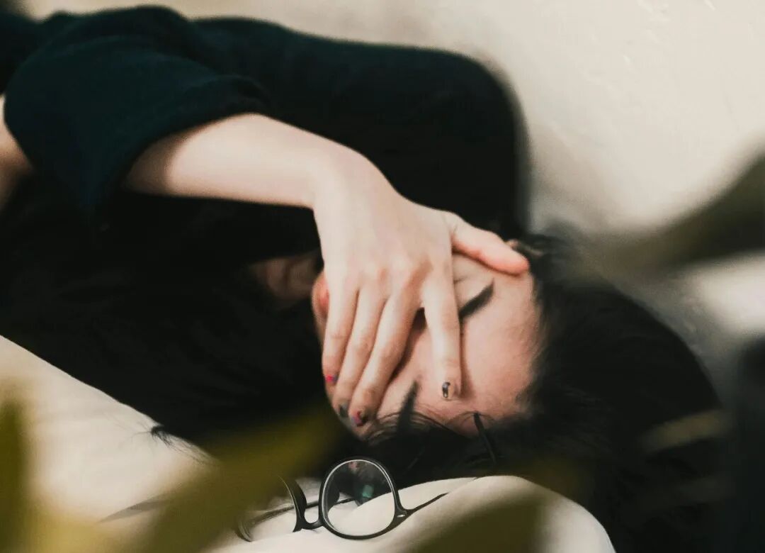 woman in black long sleeve shirt covering her face