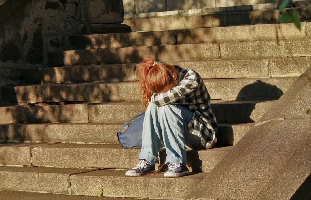 woman in black and white dress sitting on concrete stairs