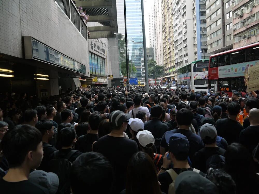 Free Massive crowd gathered on a busy city street for protest, showcasing unity and urban density. Stock Photo