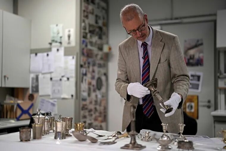 Matthias Weniger lifts one of the 111 silver objects stolen by the Nazis from the Jews during the Third Reich, in Munich, Germany
