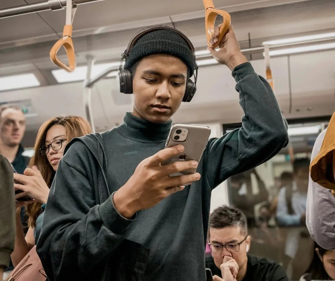 man in train holding smartphone