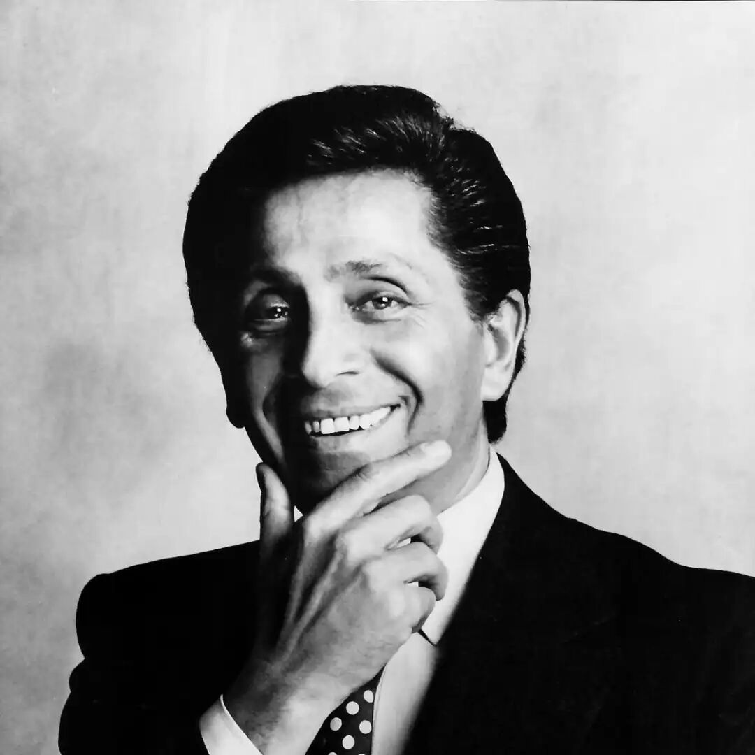a man in a suit with a hand to his chin conveying a thoughtful demeanor