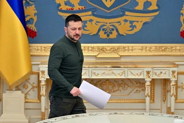 President Volodymyr Zelensky of Ukraine pictured in front of a gold-trimmed panel.
