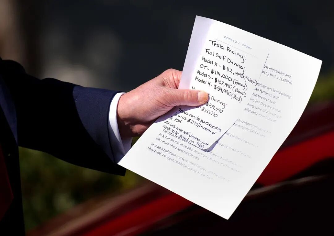President Donald Trump holds notes on the pricing of Tesla vehicles as he delivers remarks on the South Lawn of the White House on March 11 in Washington, DC.