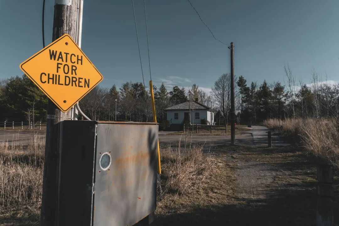 a watch for children sign on a telephone pole