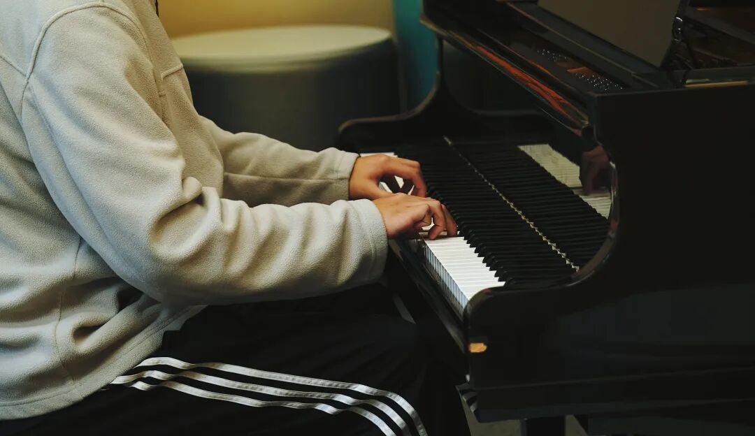 a man sitting at a piano playing a musical instrument