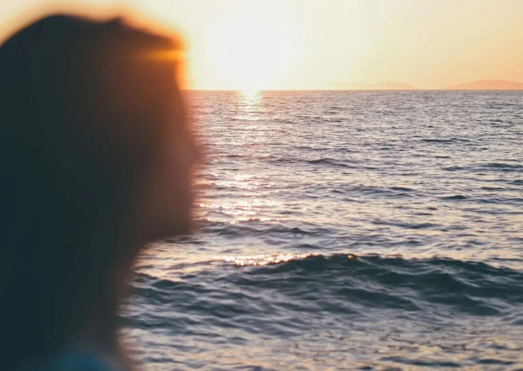 person in body of water during sunset