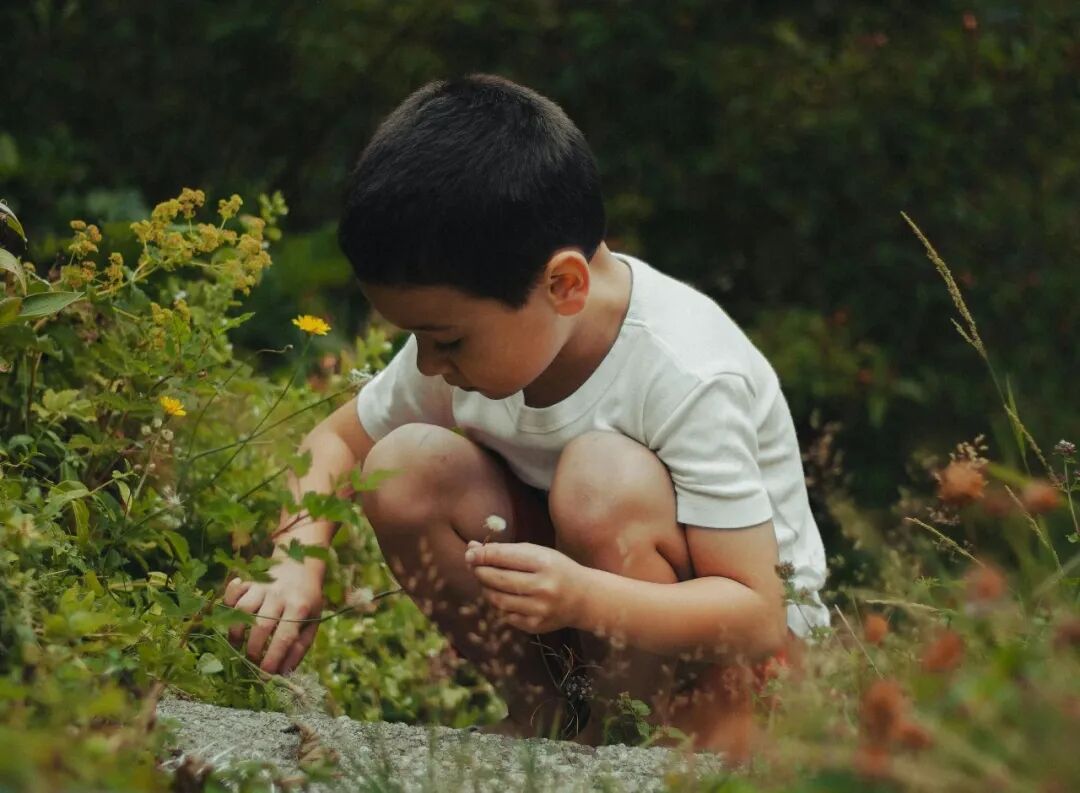 boy in white shirt sitting on ground
