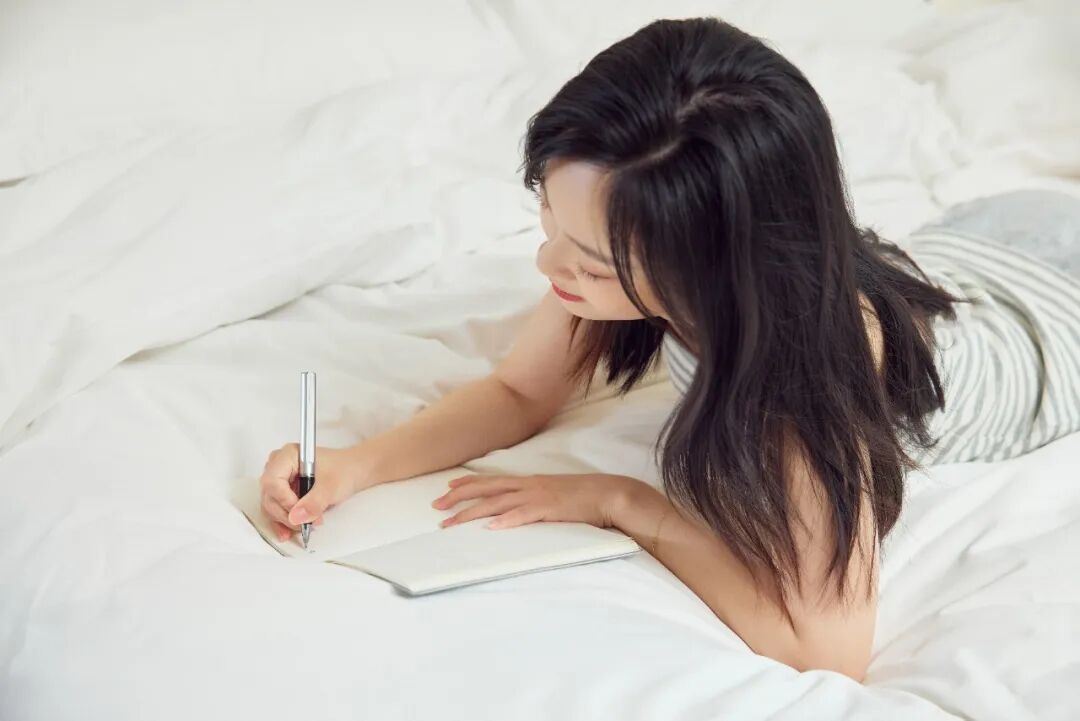摄图网_507717060_居家女生在床上写日记（企业商用）.jpg