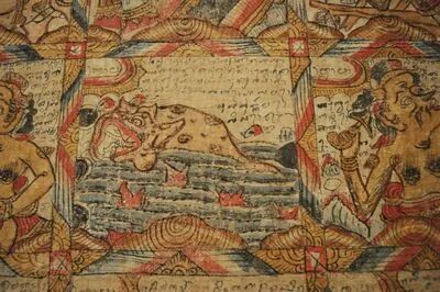 Close-up of a Balinese astrological calendar, which shows a grid filled with artwork, including a rendition of a fish.
